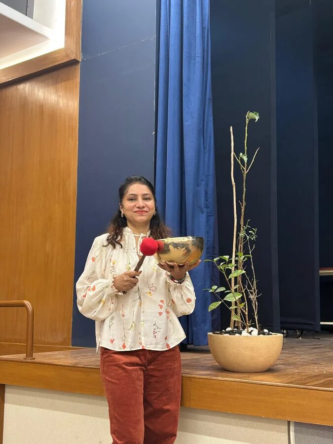 Sarabsri holding a singing bowl before a session